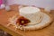 Pretty straw hat with flover on a wood table