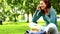 Pretty student talking on phone on the grass