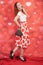 Pretty stylish pin up girl in white shirt and red polka dot vintage skirt standing on red hearts background