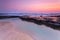 Pretty sunrise over the beach and rock shelf with reflections