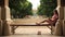 Pretty teenage girl lying down on bench in university campus and reading a book barefoot