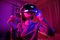 Pretty teenage girl wearing virtual reality headset in a dark room. Cute teen using VR glasses to play a game. Child in virtual