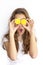 Pretty teenager girl covering her eyes with cut lemons. Lemon sunglasses