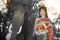 The pretty Thai lady in Middle Thai classical traditional dress suit standing is posing on elephant background.