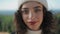 Pretty tourist posing outdoors in knitted hat closeup. Cheerful girl enjoying