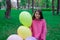 pretty tween teenager brunette girl in pink holding colorful hot air balloons outdoors. party, birthday concept