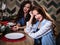 Pretty twins young women together in a kitchen room, casual home style, new year christmas decorations