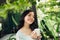 Pretty vietnamese woman enjoying her morning coffee on a veranda