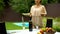 Pretty waiter serving table for celebration in country house, catering service