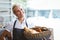 Pretty waitress carrying basket of bread