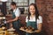 Pretty waitress holding a tray of muffins