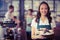 Pretty waitress showing a plate of cupcakes