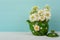 Pretty White Spring Flowers in a Vintage Asian Pot on Wood Table with Teal Boards Background in shabby chic style.  It`s a Horizo
