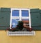 Pretty Window with Green Shutters and Window Box made of White Picket Fence