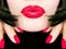 pretty woman with black hair, red lips and fingernails sending a kiss / smooch