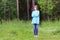 Pretty woman in blue stands in forest