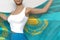 Pretty woman in bright skirt holds Kazakhstan flag in hands behind her back on the white background - flag concept 3d illustration