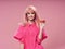 pretty woman with cake on pink background and fashion shirt wig