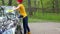 Pretty woman in colorful clothes washing black automobile car with soapy sponge.