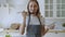 Pretty woman cooking soup on stove at kitchen. Young woman tasting soup on spoon.