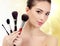 Pretty woman with cosmetic brushes