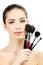 Pretty woman with cosmetic brushes