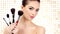 Pretty woman with cosmetic brushes