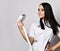 Pretty woman cosmetologist in medical uniform young professional looks at equipment for laser hair removal she holds