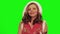 Pretty woman with curly hair wearing christmas costume sings against chromakey.