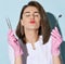 Pretty woman dentist in gloves and uniform holds dental tools and mirror for teeth examination and sends a kiss