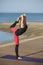 Pretty woman doing yoga on the beach