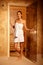 Pretty woman at door of sauna