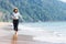 A pretty woman is enjoying a serene beach. Foreground on seawater splashing