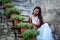 Pretty woman in ethnic Mediterranean traditional costume sitting on stone stairs.