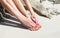 Pretty woman feet with red manicure and pedicure: relaxing on sand.