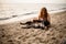 pretty woman has fun and plays with her dog on the sandy beach