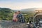 Pretty woman and her incapacitated husband sit near his wheelchair on the hill and kissing gently.