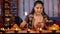 A pretty woman keeping brightly burning Diyas on a table - Diwali celebrations