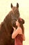 Pretty woman kissing her black horse