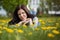 Pretty woman lying down on dandelions field, happy cheerful gir