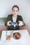 Pretty woman makes a photo of her food at the restaurant. A blogger photographs a sandwich and a salad on a smartphone