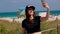 Pretty woman at Miami Beach takes a selfie at the beach