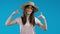 Pretty woman pointing down to advertising area. Blue background. Young lady asking to click to subscribe below. Copy