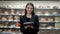 Pretty woman posing in front of the counter presenting coffee and pie at the supermarket