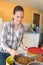 Pretty woman preparing bowls dog food at animal shelter