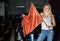 Pretty woman with race flag standing near car