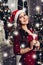 Pretty woman in red dress standing near and christmas tree