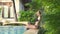Pretty woman relaxing on poolside after swimming at summer holiday in resort hotel. Young woman posing outdoor pool at