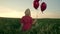 Pretty woman in retro red dress posing with heart-shaped balloons in green field. Girl in straw vintage hat or beret