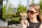 Pretty woman in sunglasses with small chihuahua in hands
